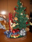 Centro de Navidad con arbol y motivos florales sobre peana de madera